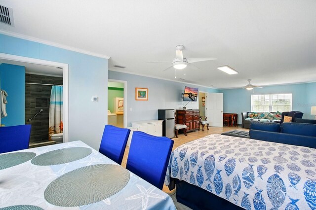7029 N Ocean Shore Blvd, Palm Coast, FL 32137 - bedroom featuring crown molding, freestanding refrigerator, ceiling fan, and ensuite bathroom