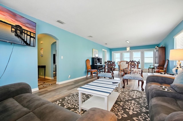 7029 N Ocean Shore Blvd, Palm Coast, FL 32137 - living area with arched walkways, wood finished floors, and baseboards