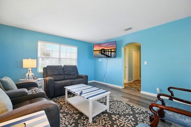 7029 N Ocean Shore Blvd, Palm Coast, FL 32137 - living room featuring arched walkways, wood finished floors, and baseboards