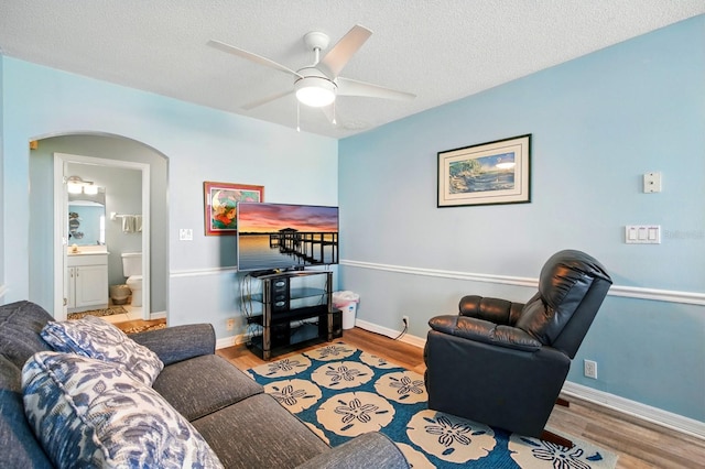 7029 N Ocean Shore Blvd, Palm Coast, FL 32137 - living area featuring wood finished floors, ceiling fan, arched walkways, baseboards, and a textured ceiling