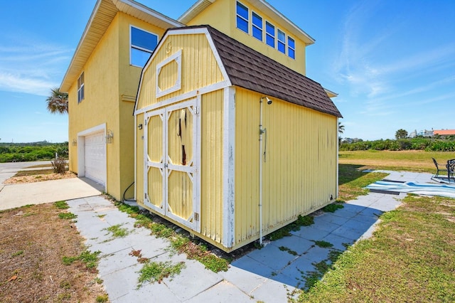 7029 N Ocean Shore Blvd, Palm Coast, FL 32137 - view of outbuilding with an attached garage, concrete driveway, and an outbuilding