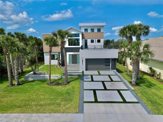 807 N Flagler Ave, Flagler Beach, FL 32136 - contemporary home with a balcony, driveway, stucco siding, a front lawn, and an attached garage