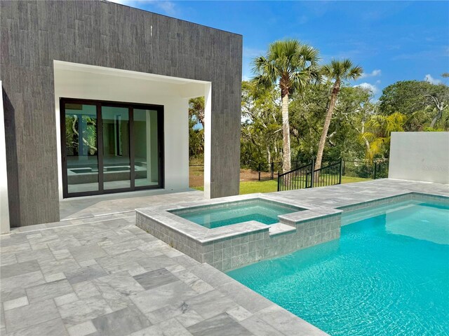 807 N Flagler Ave, Flagler Beach, FL 32136 - view of swimming pool with a patio area, fence, and a pool with connected hot tub