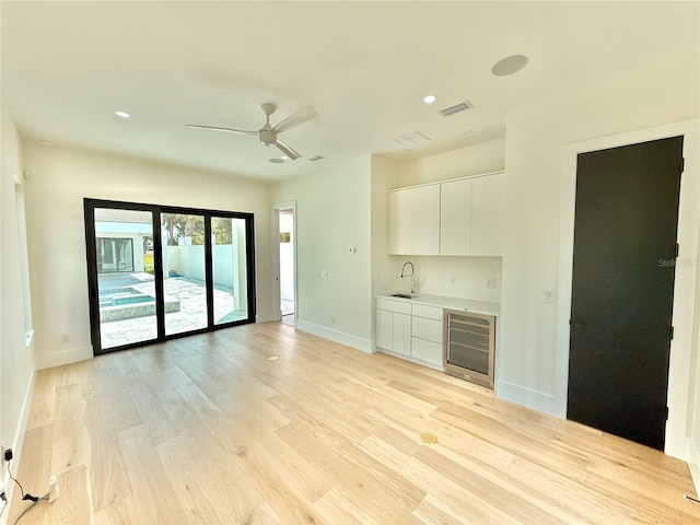 807 N Flagler Ave, Flagler Beach, FL 32136 - unfurnished living room featuring beverage cooler, light wood-style floors, baseboards, ceiling fan, and recessed lighting