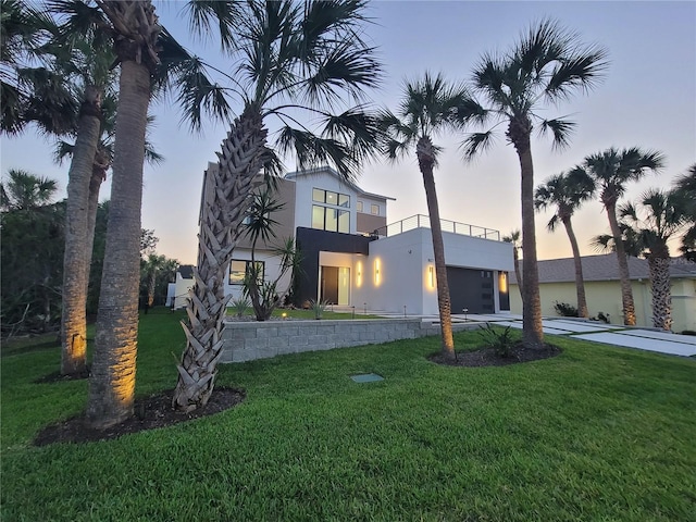 807 N Flagler Ave, Flagler Beach, FL 32136 - view of front of house featuring a balcony, a front yard, and stucco siding