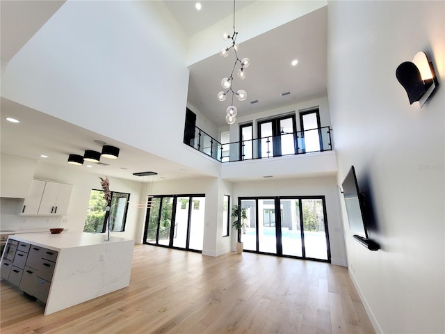 807 N Flagler Ave, Flagler Beach, FL 32136 - unfurnished living room featuring a high ceiling, light wood finished floors, plenty of natural light, recessed lighting, and baseboards