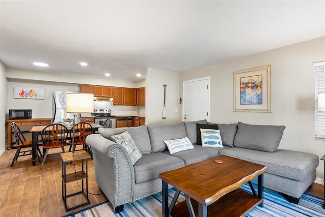 living room with light wood-style flooring, recessed lighting, and baseboards