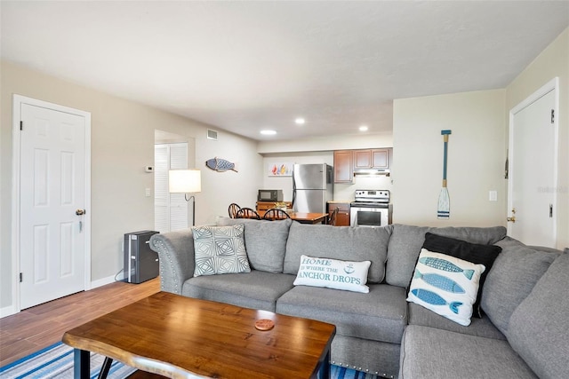 living area featuring light wood-type flooring, recessed lighting, and baseboards