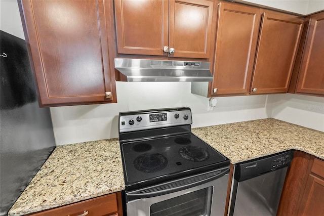 kitchen with appliances with stainless steel finishes, under cabinet range hood, light stone countertops, and brown cabinetry