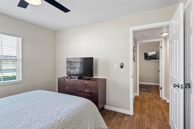 bedroom with wood finished floors, baseboards, and ceiling fan