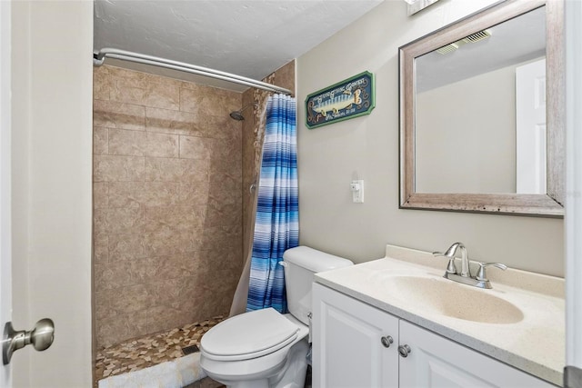 full bath with toilet, tiled shower, and vanity