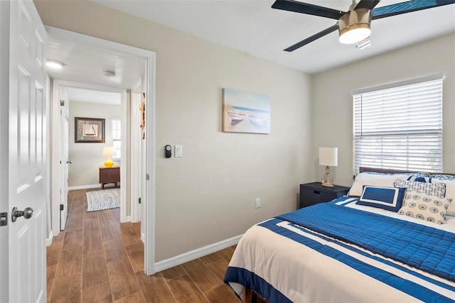 bedroom with wood finished floors, baseboards, and ceiling fan