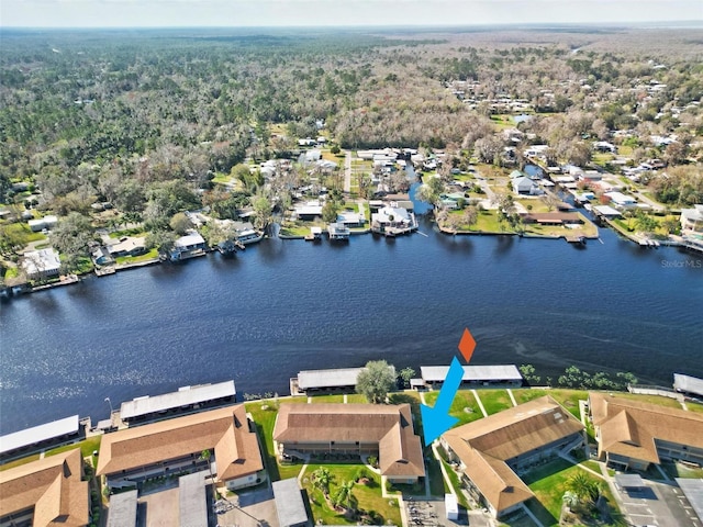 aerial perspective of suburban area featuring a large body of water and a heavily wooded area