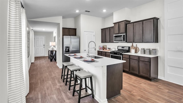 804 Grand Reserve Dr, Bunnell, FL 32110 - kitchen with stainless steel appliances, a sink, light wood-style flooring, a kitchen breakfast bar, and recessed lighting