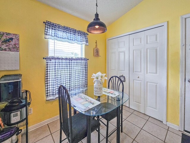 7 Bunker View Dr, Palm Coast, FL 32137 - dining room featuring light tile patterned flooring, a textured ceiling, lofted ceiling, and baseboards