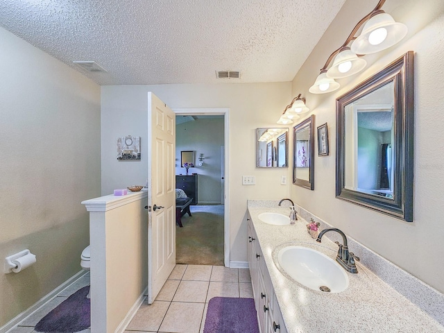 7 Bunker View Dr, Palm Coast, FL 32137 - full bath featuring toilet, double vanity, a textured ceiling, tile patterned floors, and ensuite bath