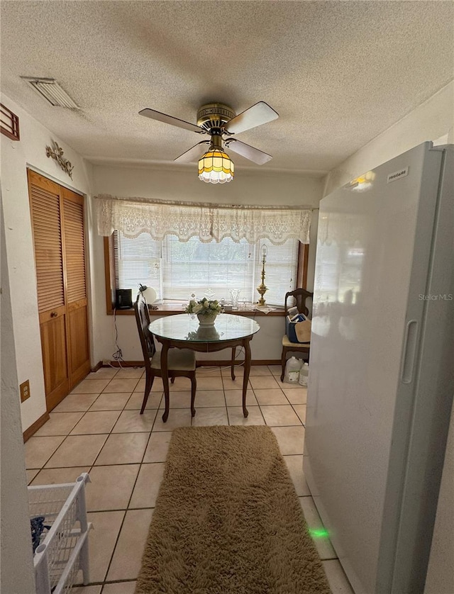 486 S US Highway 1, Oak Hill, FL 32759 - dining space featuring light tile patterned flooring, a textured ceiling, ceiling fan, and baseboards