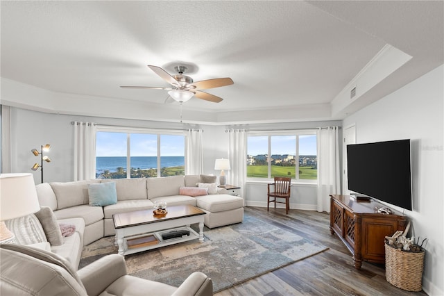 living room with a ceiling fan, wood finished floors, crown molding, baseboards, and a textured ceiling