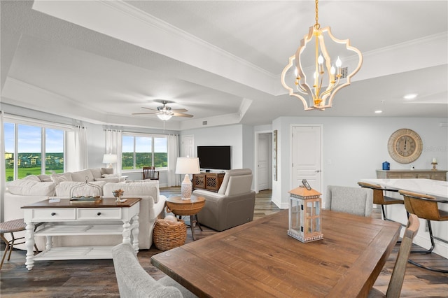 living room with dark wood finished floors, crown molding, a ceiling fan, a raised ceiling, and a chandelier