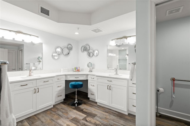 bathroom with wood finished floors, vanity, and recessed lighting