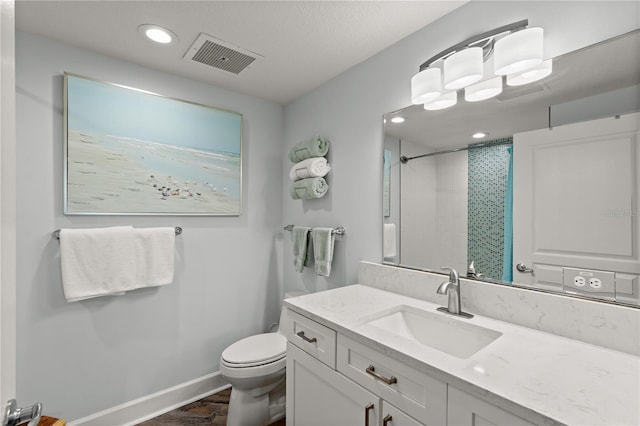 full bathroom featuring toilet, a shower, baseboards, wood finished floors, and vanity