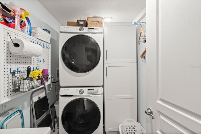 laundry room featuring stacked washer / drying machine and cabinet space