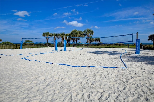 view of home's community with volleyball court and fence