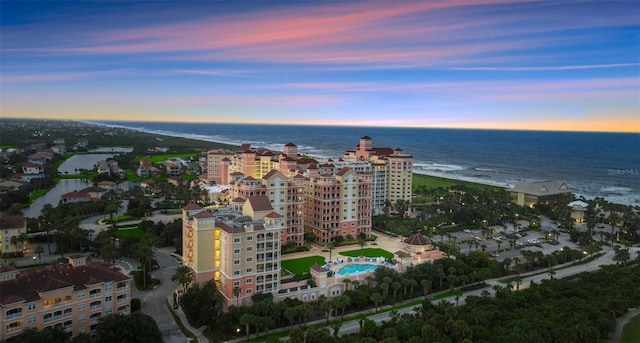 aerial view of property's location featuring a nearby body of water and a pool area
