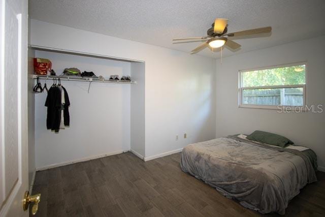 bedroom featuring wood finished floors, baseboards, a textured ceiling, and a ceiling fan