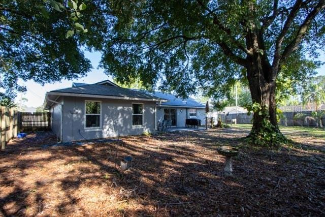 rear view of property with a fenced backyard, stucco siding, and a patio area
