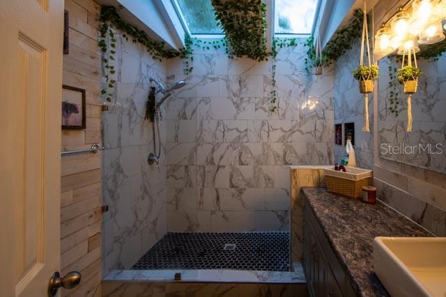 1 Belvedere Ln, Palm Coast, FL 32137 - bathroom with a skylight, tiled shower, and vanity