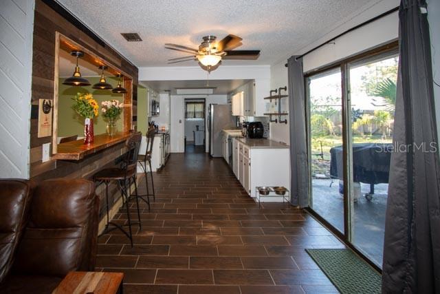 1 Belvedere Ln, Palm Coast, FL 32137 - kitchen with freestanding refrigerator, white cabinets, a textured ceiling, a ceiling fan, and decorative light fixtures