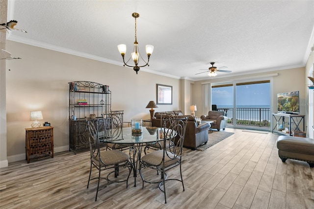 dining area with light wood finished floors, a ceiling fan, a textured ceiling, ornamental molding, and baseboards