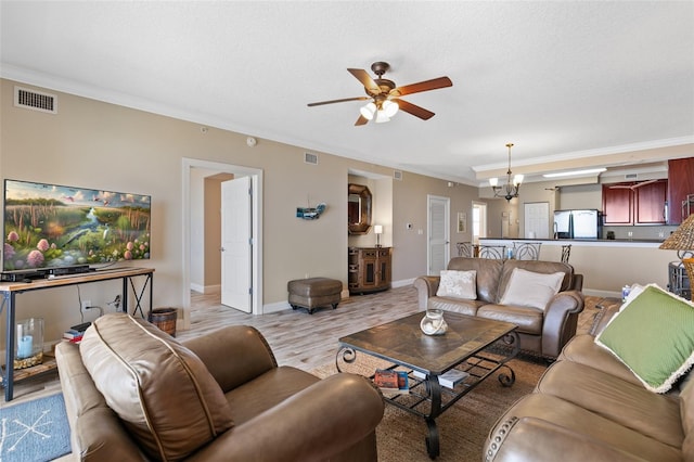 living room with ceiling fan, ornamental molding, light wood finished floors, and baseboards