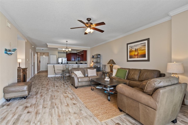 living room featuring light wood-style floors, ceiling fan, a chandelier, crown molding, and a textured ceiling