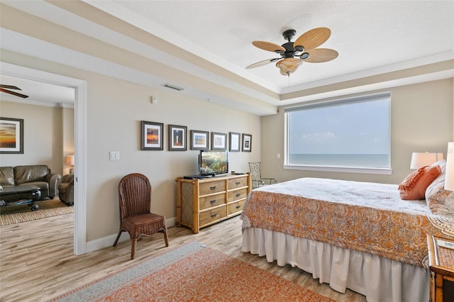 bedroom featuring wood finished floors, crown molding, baseboards, and a ceiling fan