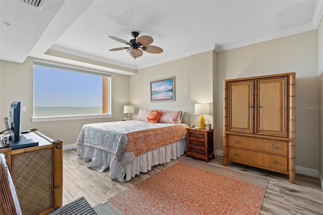 bedroom featuring baseboards, light wood finished floors, ornamental molding, a textured ceiling, and a ceiling fan