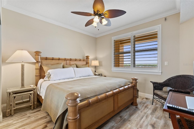 bedroom featuring light wood-style flooring, crown molding, baseboards, and ceiling fan