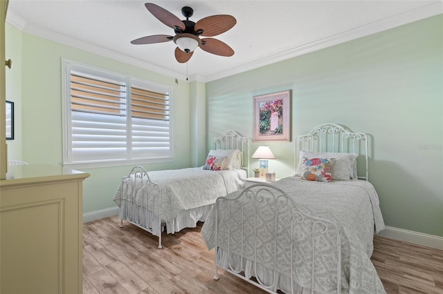 bedroom with light wood-style floors, crown molding, baseboards, and a ceiling fan