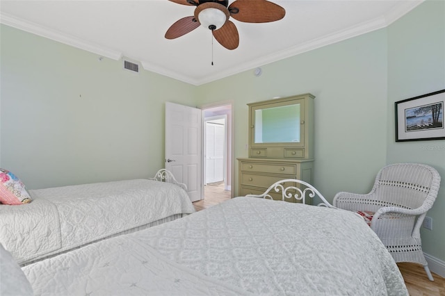 bedroom with crown molding, light wood-type flooring, baseboards, and a ceiling fan