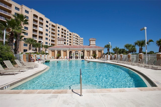 community pool with fence and a patio