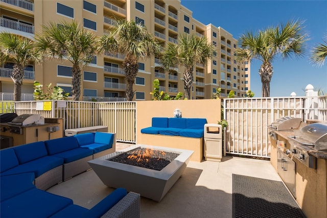 view of patio / terrace featuring an outdoor living space with a fire pit, exterior kitchen, and grilling area
