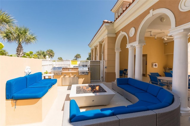 view of patio with an outdoor living space with a fire pit, exterior kitchen, a grill, and fence