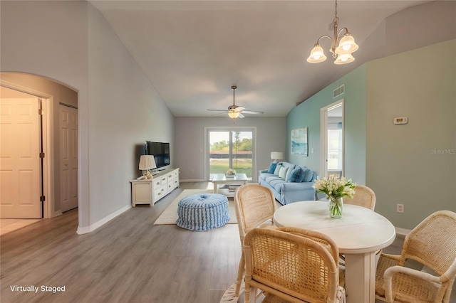 613 Clairmont Ln, South Daytona, FL 32119 - living room featuring vaulted ceiling, light wood finished floors, a ceiling fan, baseboards, and a chandelier