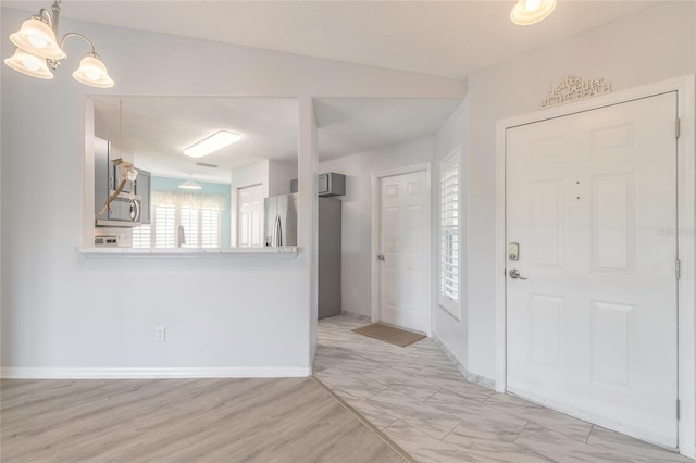 613 Clairmont Ln, South Daytona, FL 32119 - entryway featuring a chandelier, baseboards, and light wood-type flooring