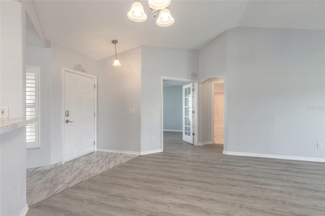 613 Clairmont Ln, South Daytona, FL 32119 - entryway with vaulted ceiling, wood finished floors, arched walkways, a chandelier, and baseboards