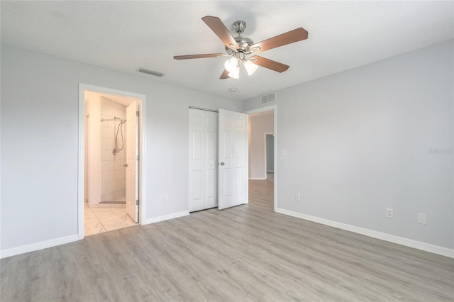 613 Clairmont Ln, South Daytona, FL 32119 - unfurnished bedroom with light wood finished floors, baseboards, a closet, ensuite bathroom, and ceiling fan