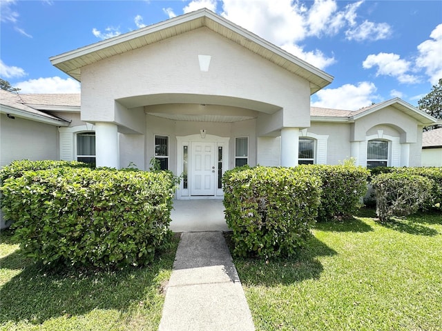 15 Ruth Dr, Palm Coast, FL 32164 - doorway to property featuring a lawn and a shingled roof