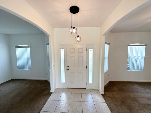 15 Ruth Dr, Palm Coast, FL 32164 - carpeted foyer entrance with arched walkways, tile patterned floors, and baseboards