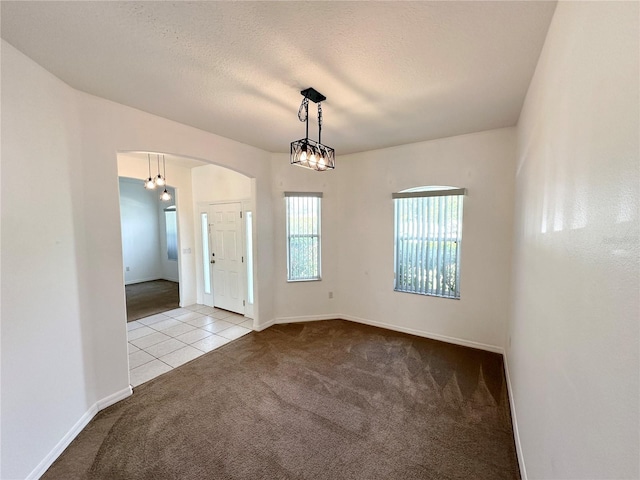 15 Ruth Dr, Palm Coast, FL 32164 - carpeted spare room featuring arched walkways, tile patterned flooring, baseboards, and a textured ceiling